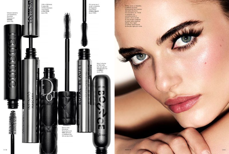 Close-up of a woman with dramatic eye makeup and long lashes, next to several open mascara containers in a beauty advertisement.