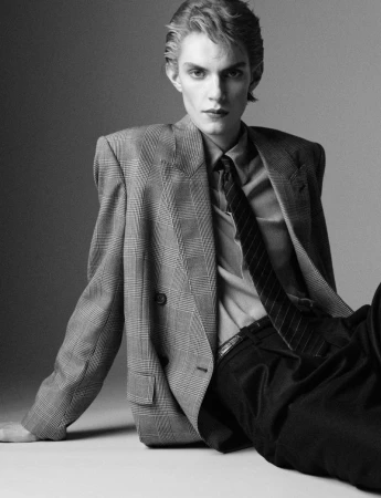 Model Alvar af Schulten wearing a plaid double-breasted blazer and tie in a black-and-white fashion portrait for Dapper Dan Magazine.