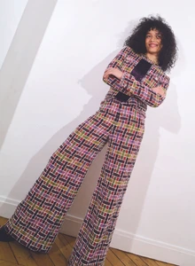 Whitney Peak wearing a patterned tweed matching set against a plain white wall for Love Want