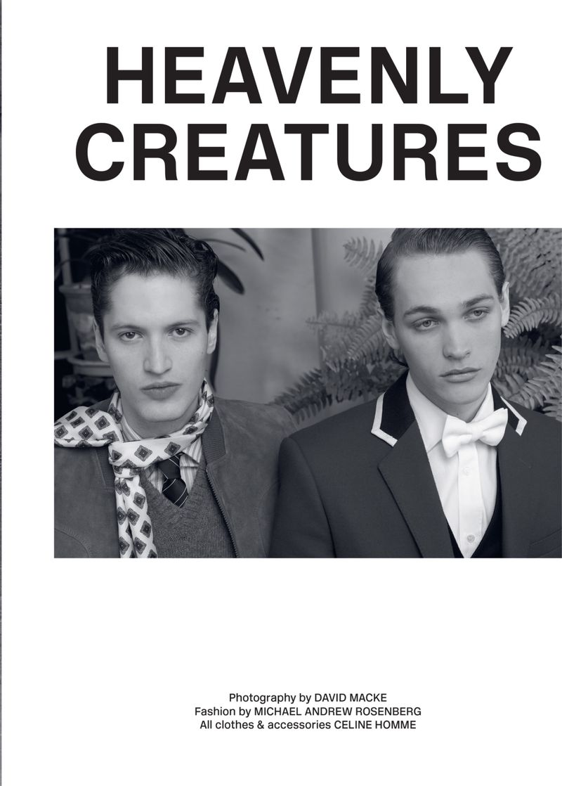 Black and white fashion portrait features two young adult men in jackets and ties, looking off-camera against a blurred background.