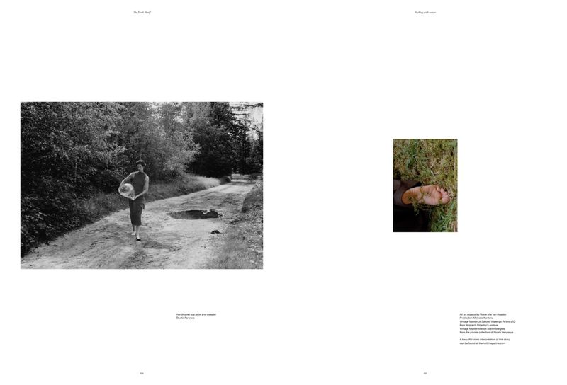 Monochrome photo of a woman walking on a dirt road carrying a white object, surrounded by lush trees and foliage.