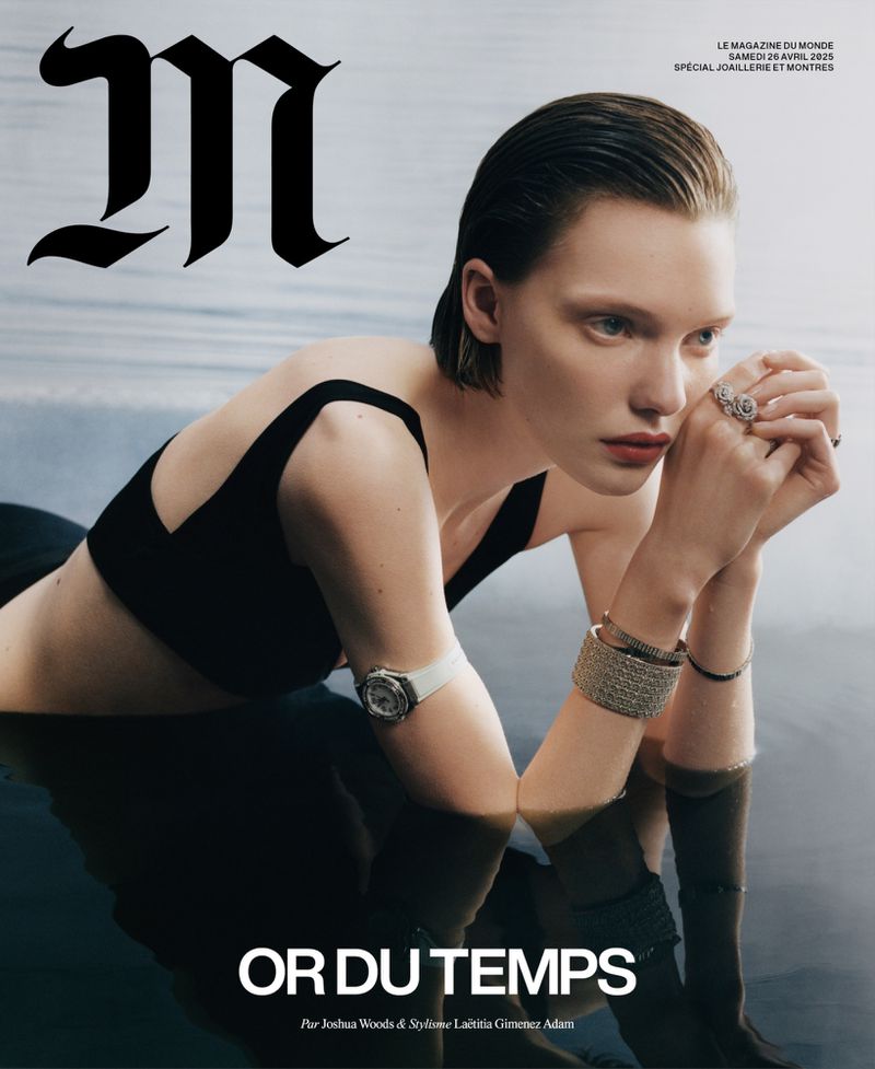 Magazine cover featuring a fair-skinned woman with wet hair, wearing a black top and jewelry, partially submerged in water with reflections.