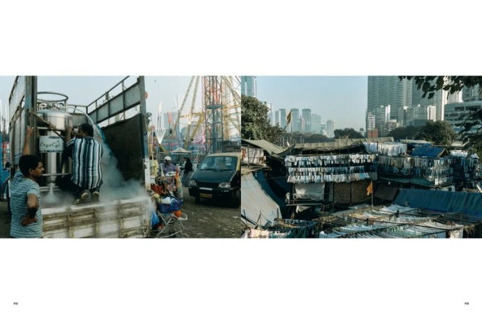 Street scene in India showing men loading a truck with tanks, a roadside vendor, auto rickshaw, and buildings in the background.