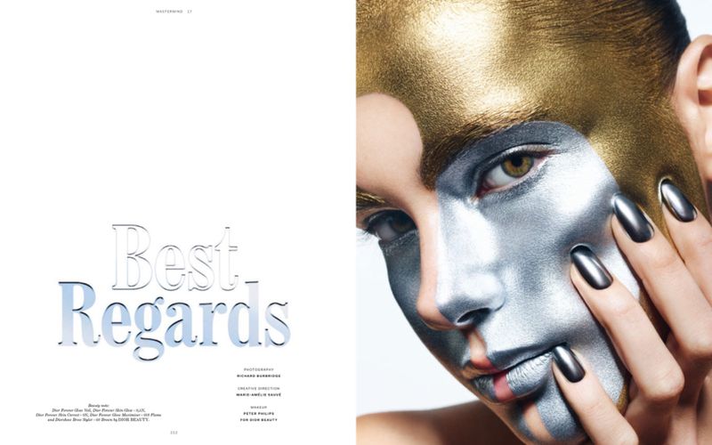 Close-up of woman with metallic gold and silver body paint, dark nails, and gazing at the camera in a beauty editorial shoot.