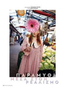Woman holding large pink gerbera daisy in front of face wearing pink patterned dress with white collar in bustling public market