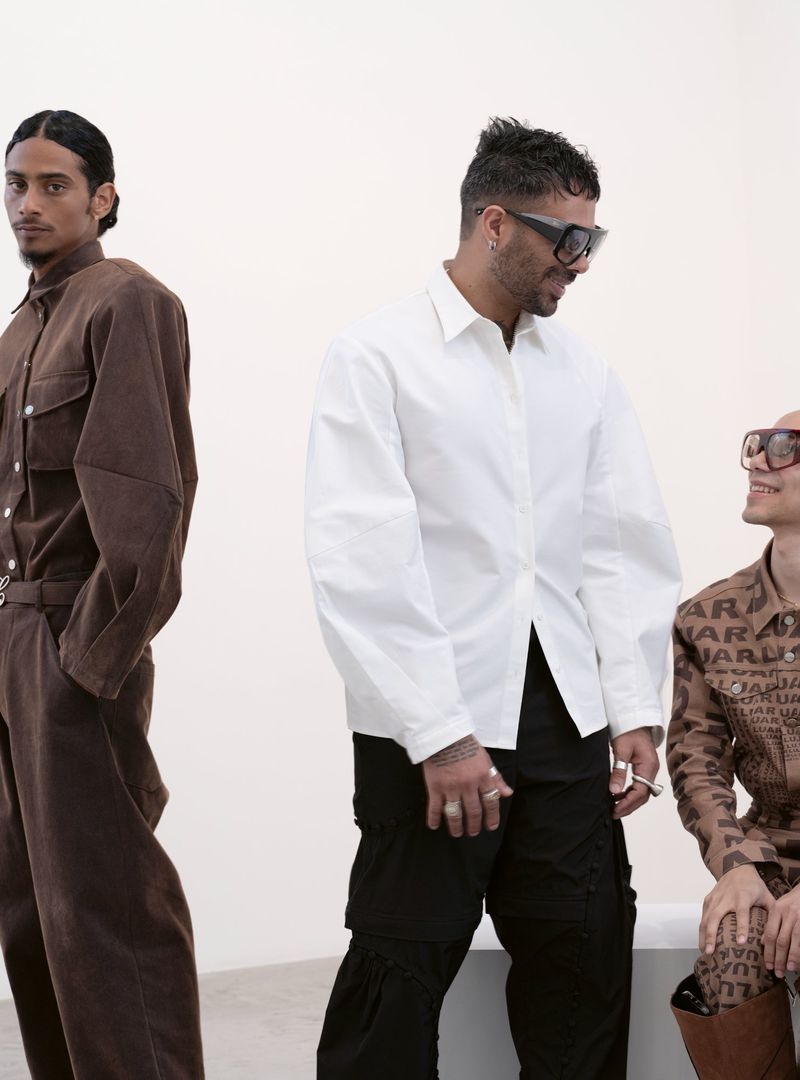 Three models wearing stylish contemporary apparel against a plain white studio backdrop