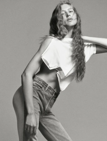 Model Angelina Kendall in a white t-shirt and denim jeans posing against a grey seamless background for Middle Plane Magazine.