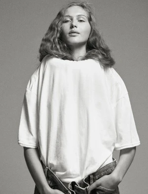 Model wearing a white t-shirt and denim jeans against a grey seamless background for Middle Plane Magazine.