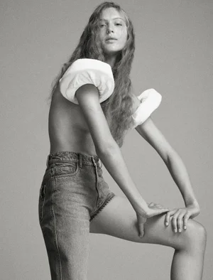 Model Angelina Kendall in denim shorts with white sculptural shoulder accents in a fashion editorial for Middle Plane Magazine