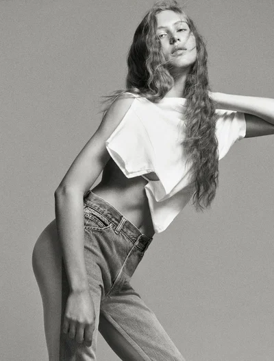 Model Angelina Kendall in a white t-shirt and denim jeans posing against a grey seamless background for Middle Plane Magazine.