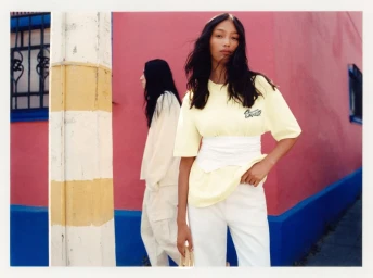Two models standing against a vibrant pink and blue building exterior in Mexico City for Pull and Bear