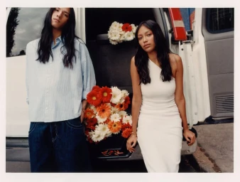 Two models standing in front of an open white van loaded with red and white flowers for a Pull & Bear campaign in Mexico City.