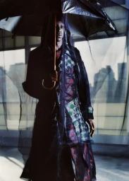 Model La Timpa holding a black umbrella under sheer fabric in an editorial photograph for Interlope Magazine.