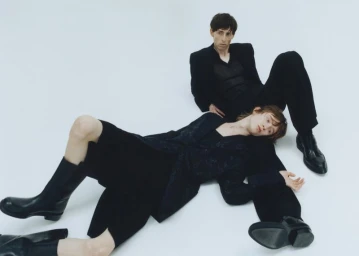 Two male models in black attire posing on a white seamless background for an editorial spread in The Greatest Magazine.