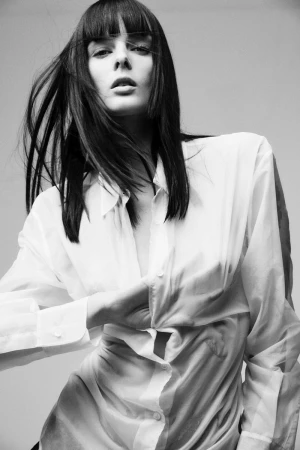 Model Aylah Peterson wearing a white buttoned shirt against a grey background for Vogue Netherlands