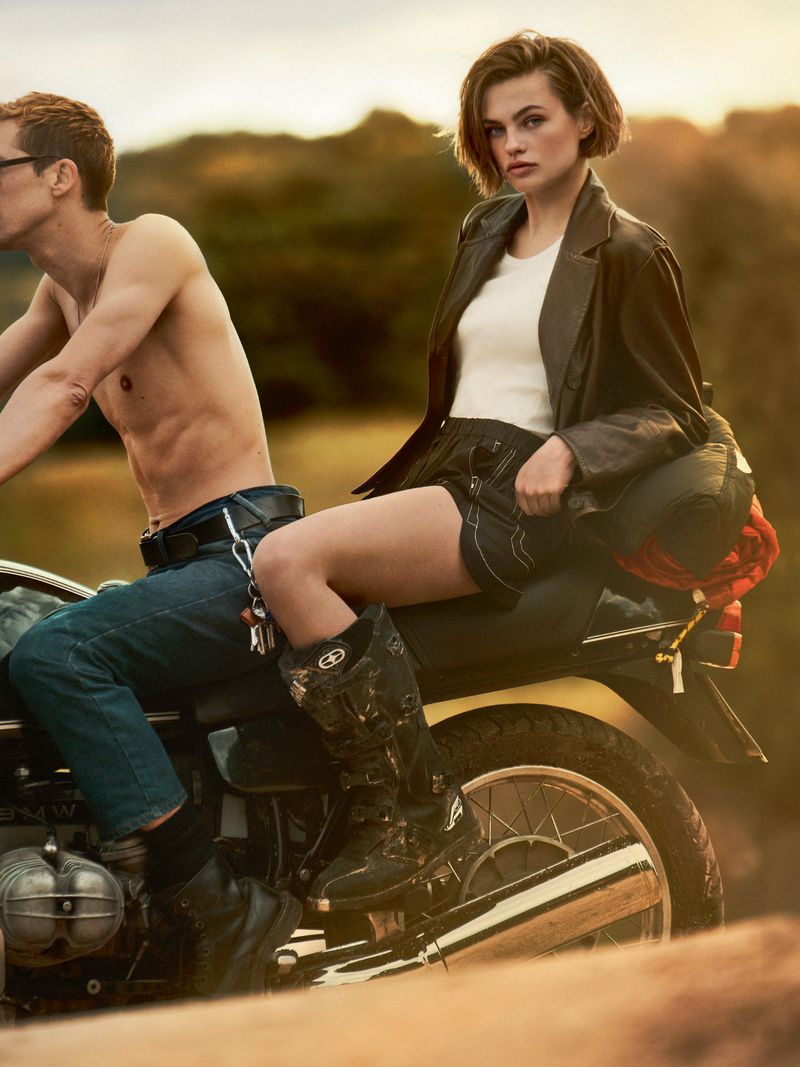 Model Anne Boomgaart wearing a dark leather jacket and boots seated on a motorcycle outdoors for Telva