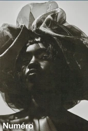 Model Alek Deng wearing a large sheer ruffled headpiece in a high-contrast monochrome fashion portrait for Numero Netherlands.