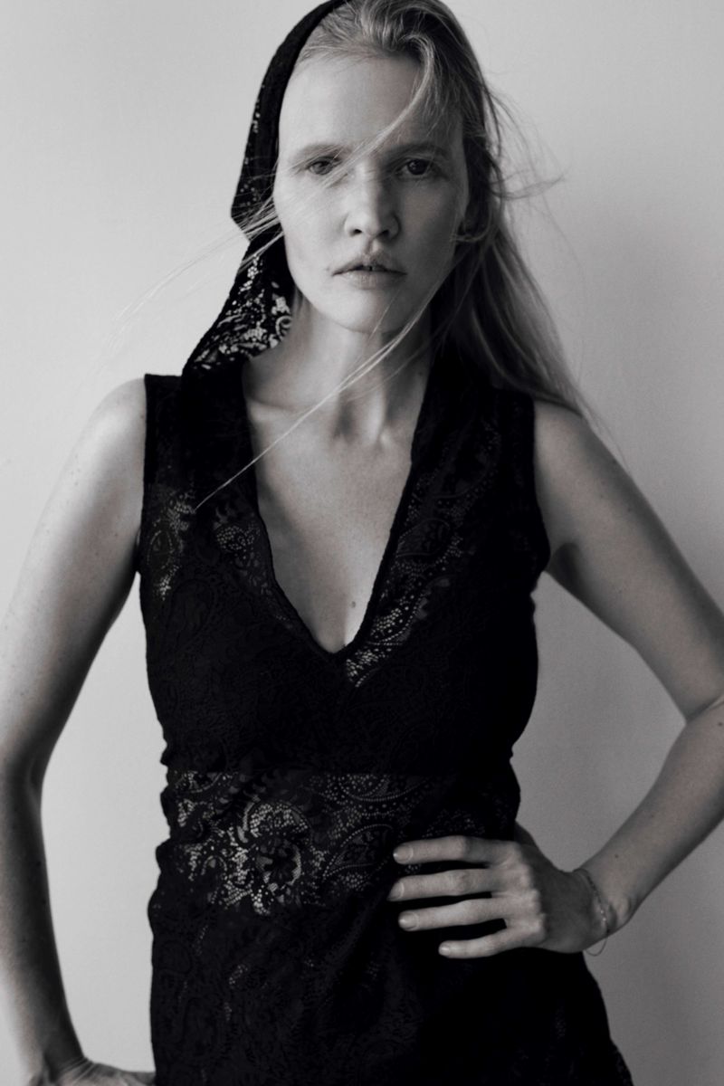 Black and white portrait of a blond adult female wearing a lace top and a headscarf, looking directly at the camera with a neutral expression.