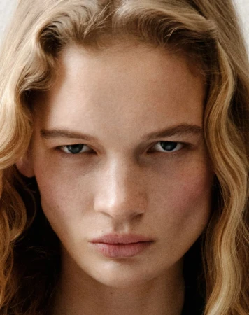 Close-up portrait of a woman with blonde wavy hair and intense expression for Present Space Double Dutch