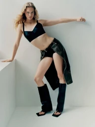 Model Caitlin Soetendal posing in black crop top and dark skirt against white seamless background for Double Dutch project