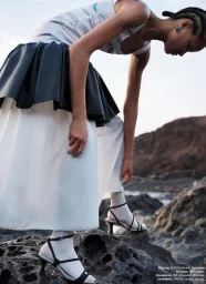 Model wearing layered skirt and strappy heels standing on rocky terrain for Damernas Varld Top Shape editorial