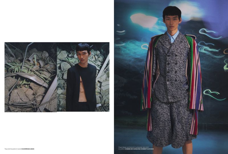 Editorial fashion shot of an Asian male model in a patterned suit with a colorful coat, posing against a dreamy, abstract background.