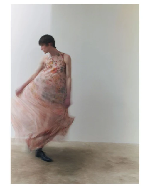 Fashion shot of a young adult in a floral dress, captured with a long exposure effect in a bright photo studio with minimalist props.