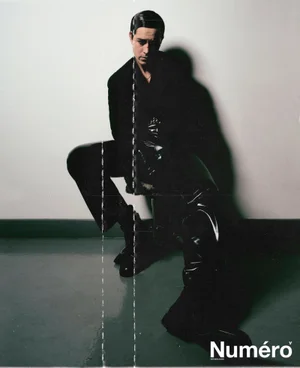 Francisco Lachowski seated wearing black attire against a plain wall for Numero Homme Netherlands editorial.
