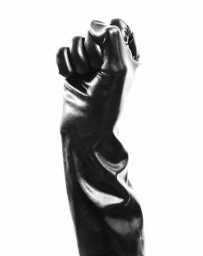 Raised fist wearing a glossy black leather glove against a plain white studio background.
