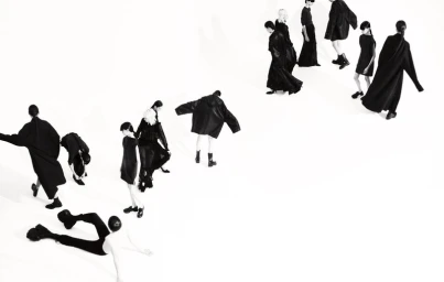 Multiple models in black attire moving diagonally across a clean white studio background in Boycott Magazine editorial