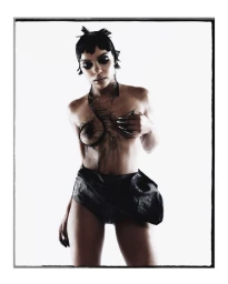 Portrait of Crystal Murray featuring avant-garde hair, body art, and dark shorts against a bright white background