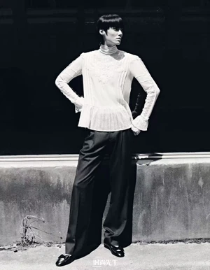 Model in white high-neck blouse and dark trousers posing outdoors for Elle Men China