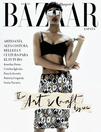 Fashion magazine cover featuring a model with sunglasses wearing a black bra top and patterned skirt against a bright white background.