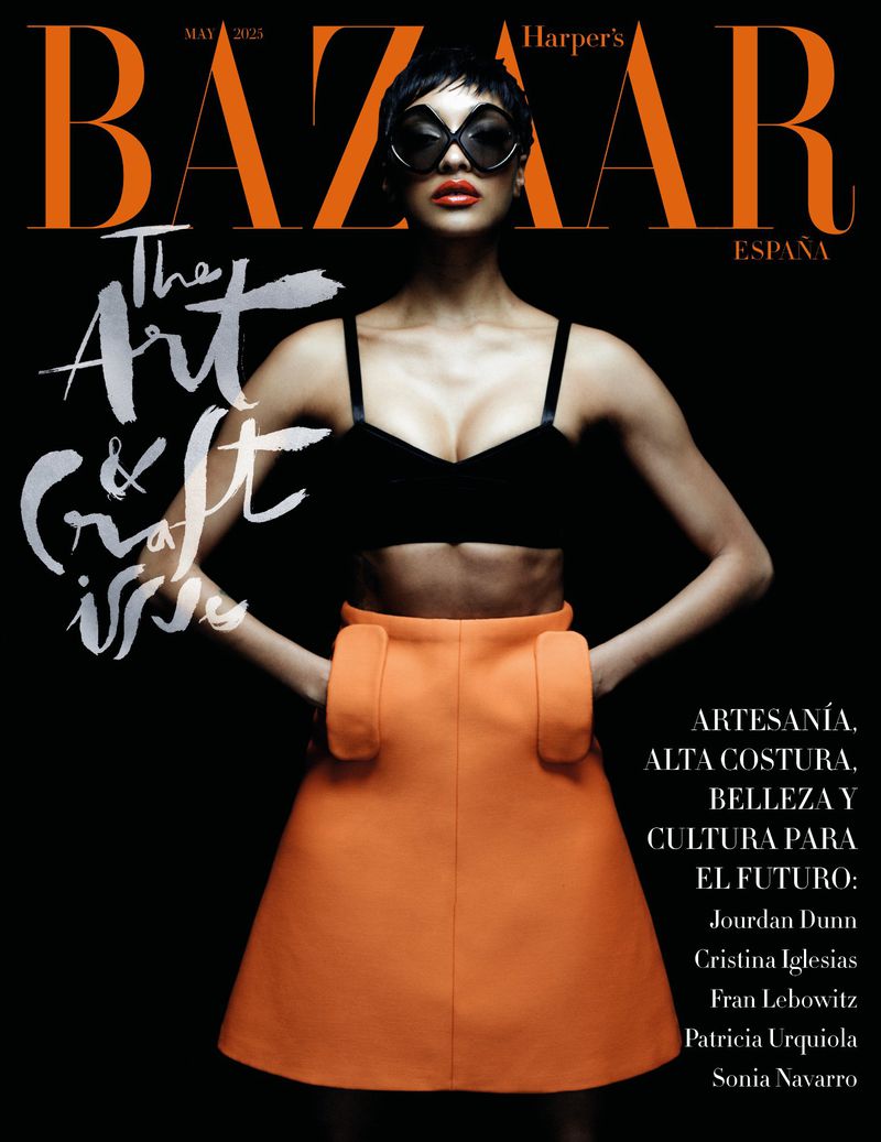 Harper's Bazaar Espana cover featuring a stylish woman with dark sunglasses, a black bra top, and an orange skirt against a black background.