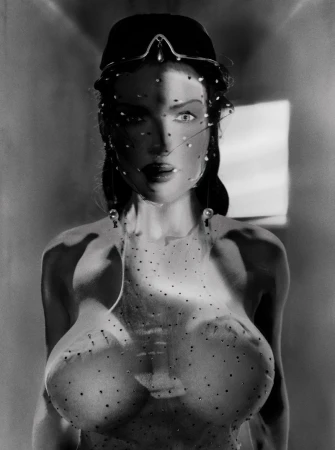 Monochrome portrait of a woman with a veil and decorative headpiece, casting soft shadows in a dimly lit indoor environment.