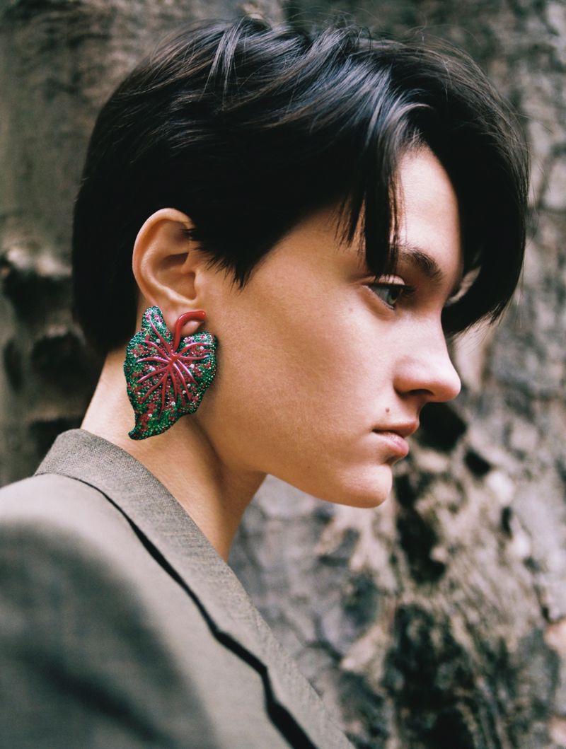 Close-up profile of model Tanya Churbanova wearing a large leaf earring and grey blazer for Exhibition Magazine.