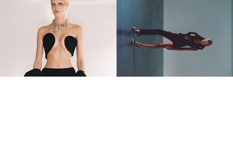 Two women pose against a minimalist backdrop, showcasing avant-garde black outfits with unique cuts and dramatic silhouettes in a fashion editorial.