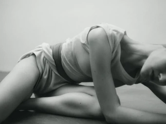 Model Angelina Artemieva posed in a low-angle black and white shot against a neutral seamless background for the project Love and death