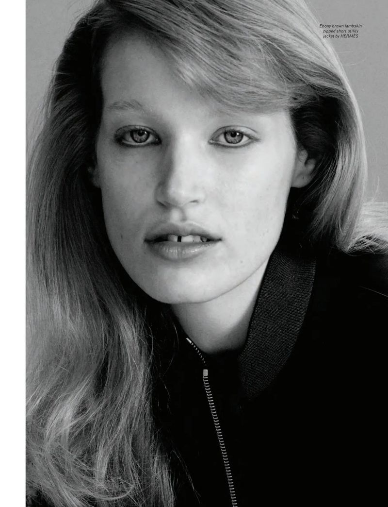 Close-up portrait of model Jacqui Hooper wearing a dark zipped jacket against a plain grey studio backdrop