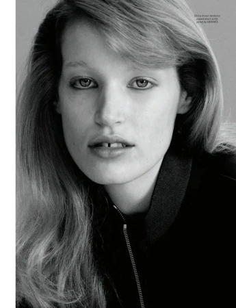 Close-up portrait of model Jacqui Hooper wearing a dark zipped jacket against a plain grey studio backdrop