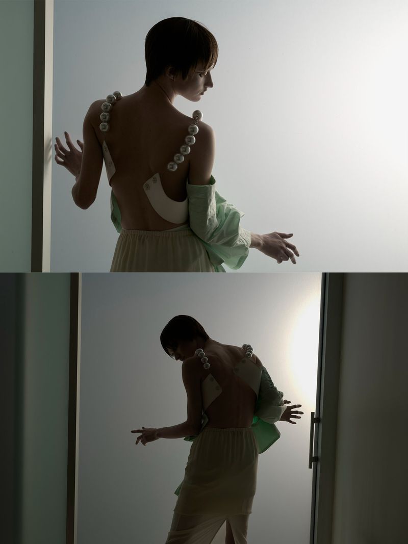 Fashion portrait of a woman in an off-the-shoulder dress with pearl straps, accessorized with an oversized mint green shirt.