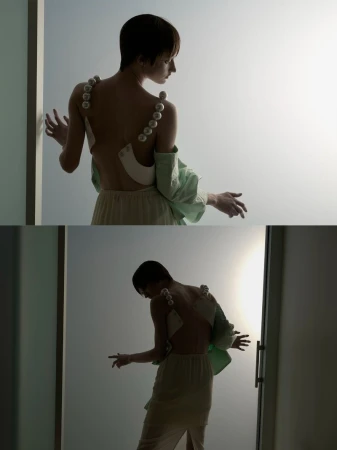 Fashion portrait of a woman in an off-the-shoulder dress with pearl straps, accessorized with an oversized mint green shirt.