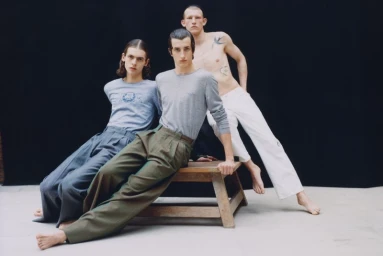 Three male models posing together on and around a wooden bench against a dark background for Lampoon Magazine.