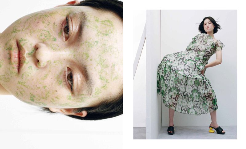 Close-up of a woman's face with green leaf-like skin treatment and a woman in a floral dress leaning against a wall.