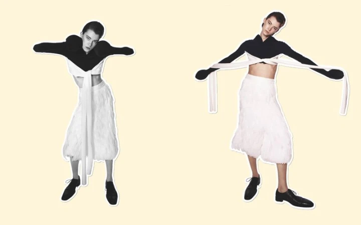 Two women pose in a studio wearing a black and white crop top with a skirt. The women strike a pose with their arms outstretched.