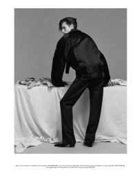 Model in black satin jacket and trousers leaning against a draped table for Pop Magazine editorial