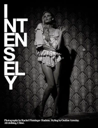 Monochrome fashion editorial image of model Lara Stone standing against a patterned wallpaper background for Self Service.