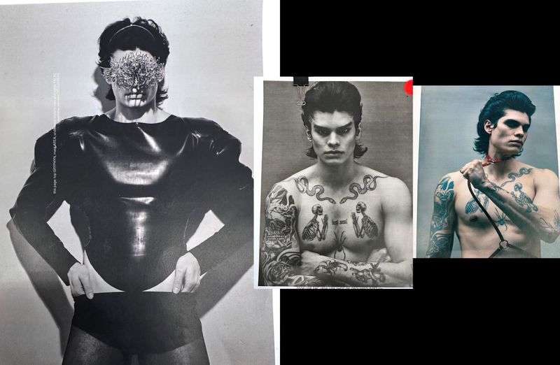Editorial shot of a tattooed male fashion model in printed magazine, posing in a black vinyl top and briefs against a white backdrop.