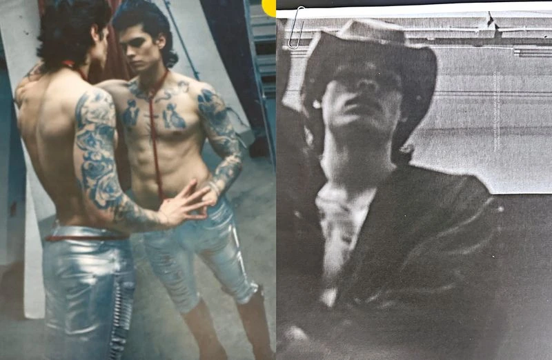 Tattooed male fashion model poses in front of a mirror wearing silver metallic pants, contrasted with a man in a cowboy hat.