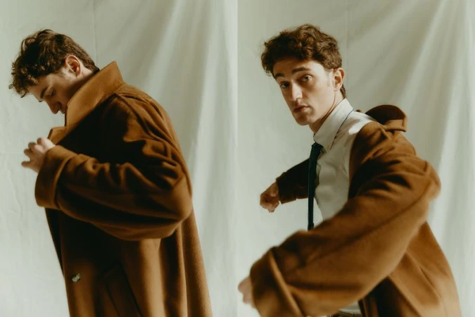 A stylish young adult male is showcased in a dual studio portrait, wearing a brown coat over a white shirt and tie, posing against a light backdrop.